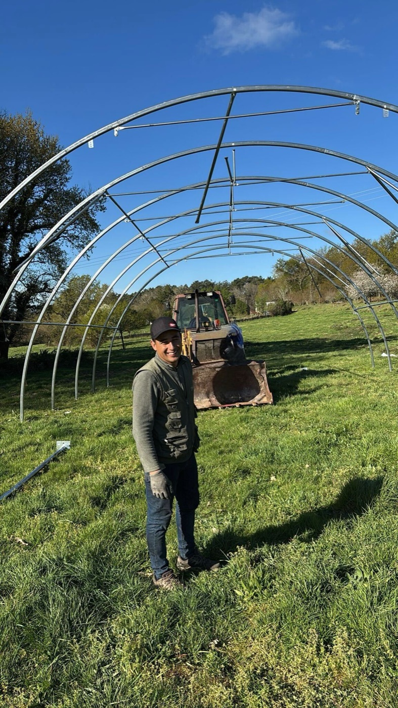 Montador ante la estructura de arcos de acero de una carpa